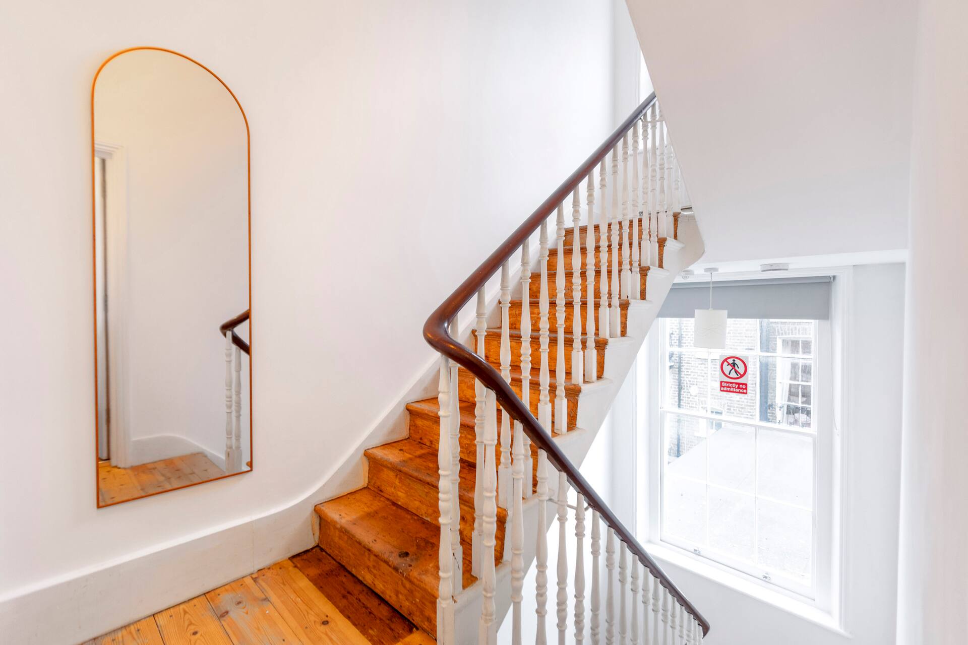 Elegant internal staircase with arched mirror in Notting Hill apartment